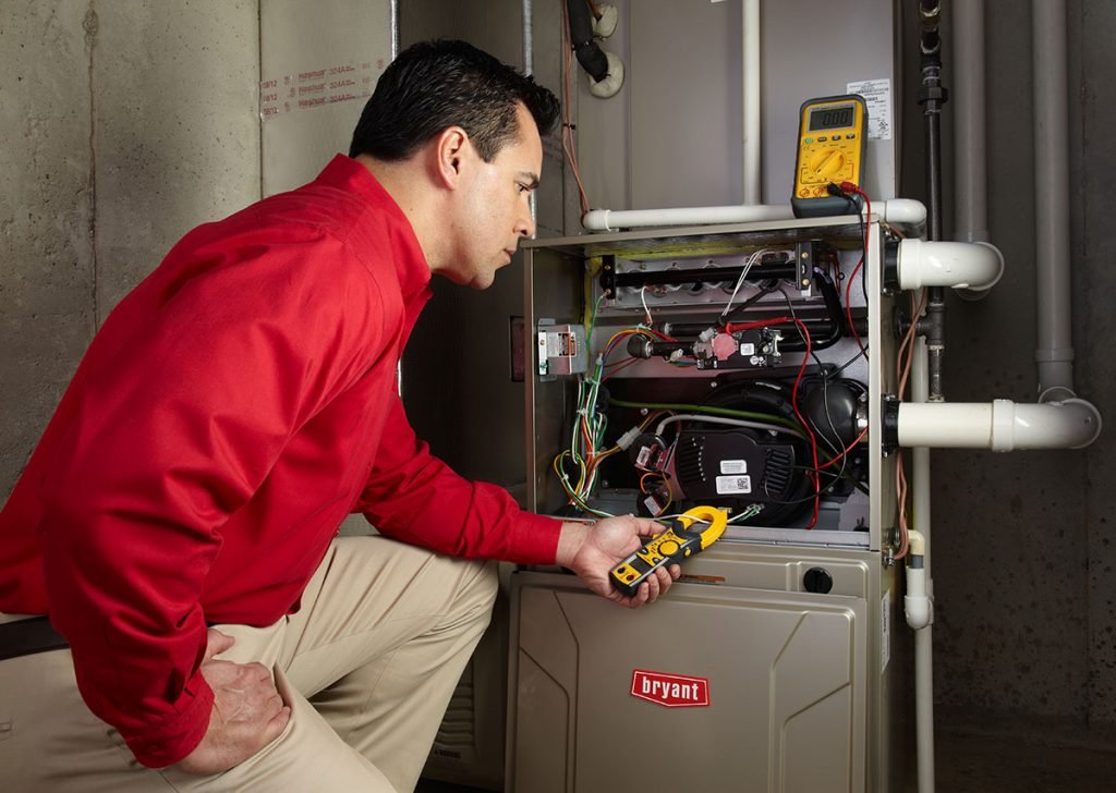 Heating and air conditioning technician servicing an indoor furnace in Claremont, CA
